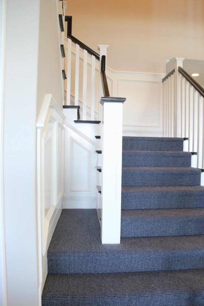На фото: большая угловая лестница в стиле кантри с ступенями с ковровым покрытием и ковровыми подступенками с