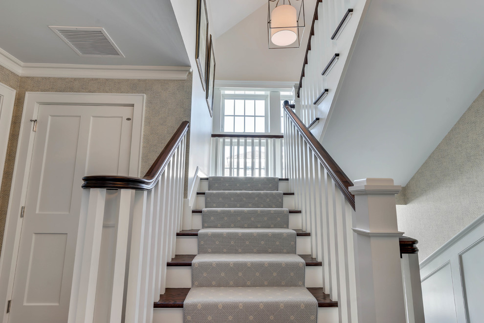 Mid-sized carpeted l-shaped wood railing staircase photo in New York with carpeted risers