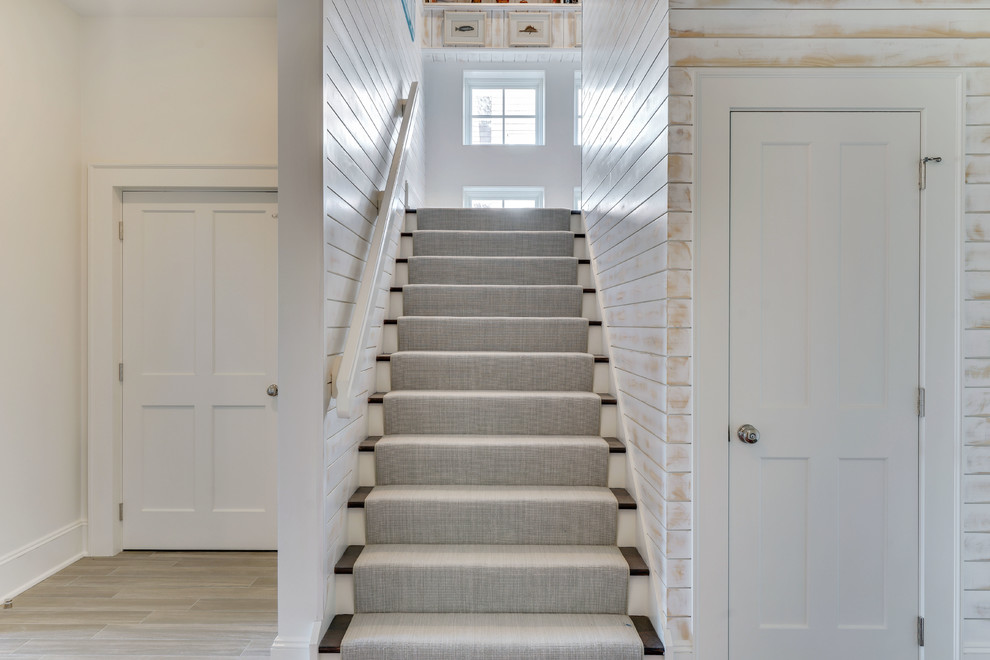 Стильный дизайн: угловая лестница среднего размера с ступенями с ковровым покрытием, ковровыми подступенками и деревянными перилами - последний тренд