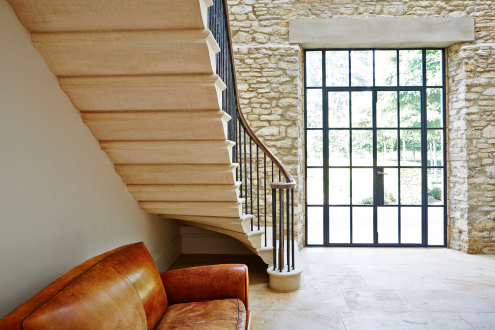 Идея дизайна: большая изогнутая металлическая лестница в стиле модернизм с мраморными ступенями