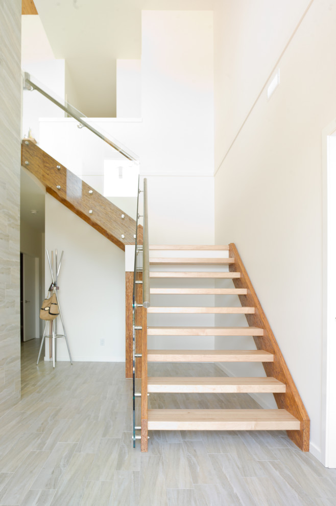 Idée de décoration pour un escalier sans contremarche minimaliste en L de taille moyenne avec des marches en bois et un garde-corps en verre.