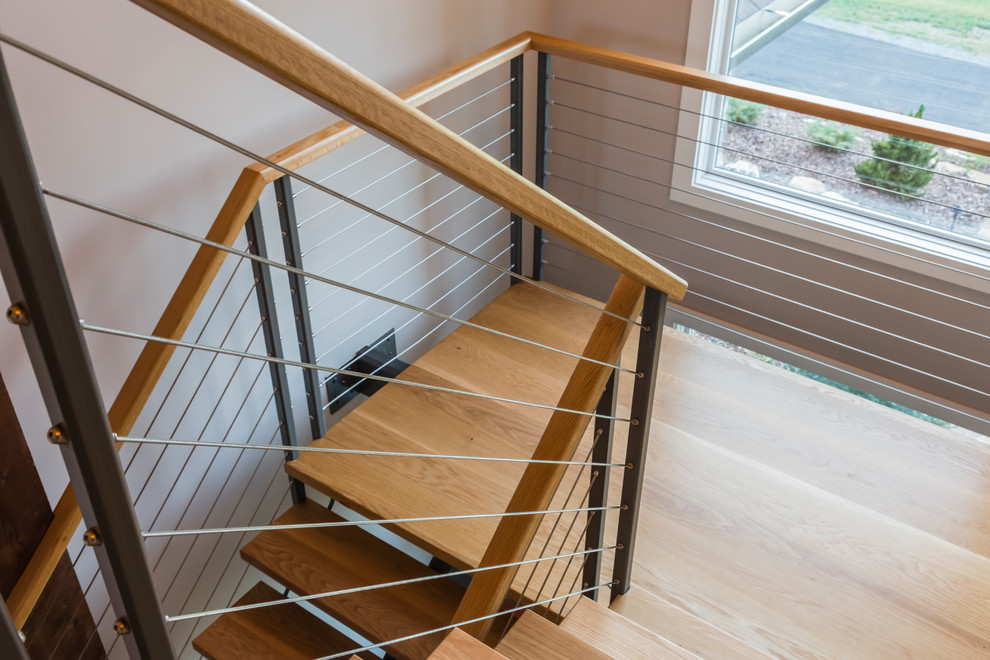 Medium sized modern wood u-shaped wire cable railing staircase in Raleigh with open risers.