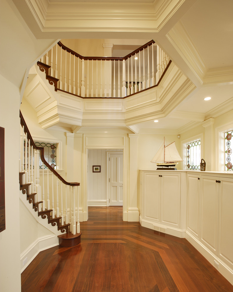 Huge elegant wooden curved staircase photo in St Louis with wooden risers