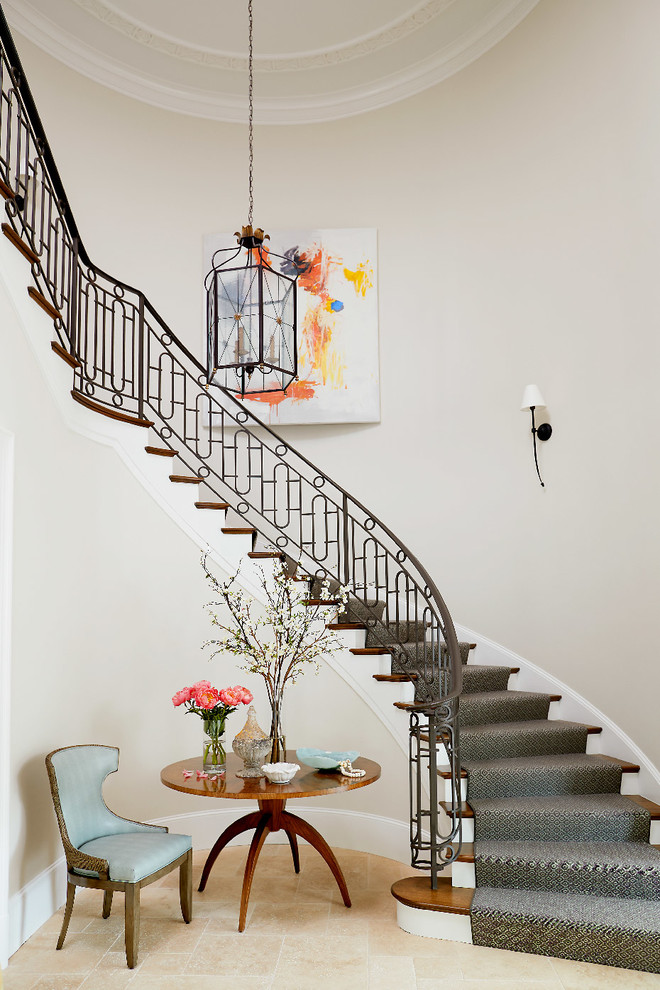 Elegant carpeted curved metal railing staircase photo in Other with carpeted risers