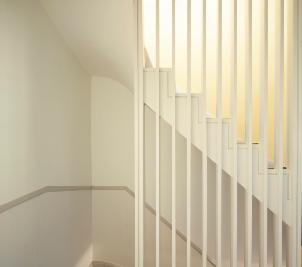 На фото: прямая лестница в скандинавском стиле с ступенями с ковровым покрытием, ковровыми подступенками и деревянными перилами с