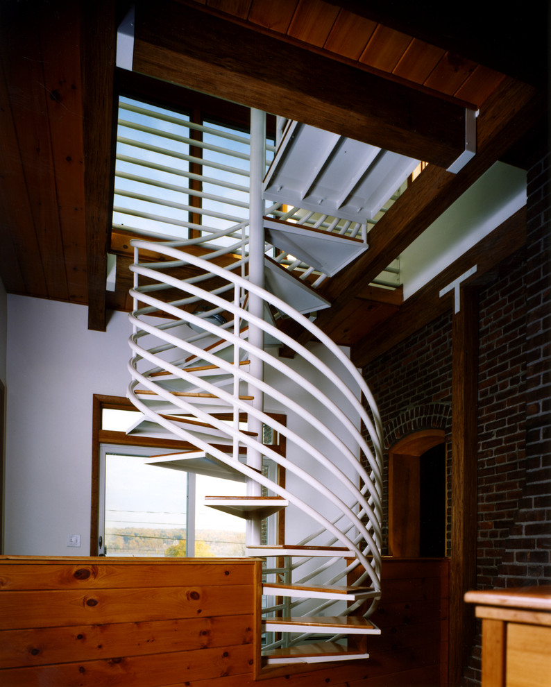 На фото: маленькая винтовая лестница в стиле фьюжн с деревянными ступенями без подступенок для на участке и в саду