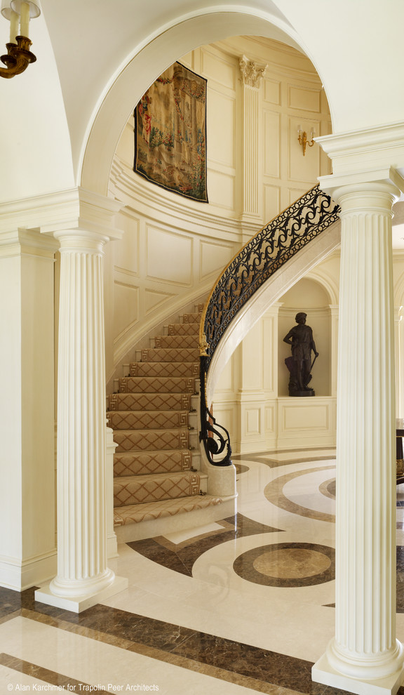 Foto på en mycket stor vintage svängd trappa i marmor, med sättsteg i marmor och räcke i metall
