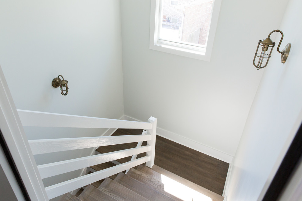 Foto de escalera en U de estilo de casa de campo de tamaño medio con escalones de madera, contrahuellas de madera pintada y barandilla de madera
