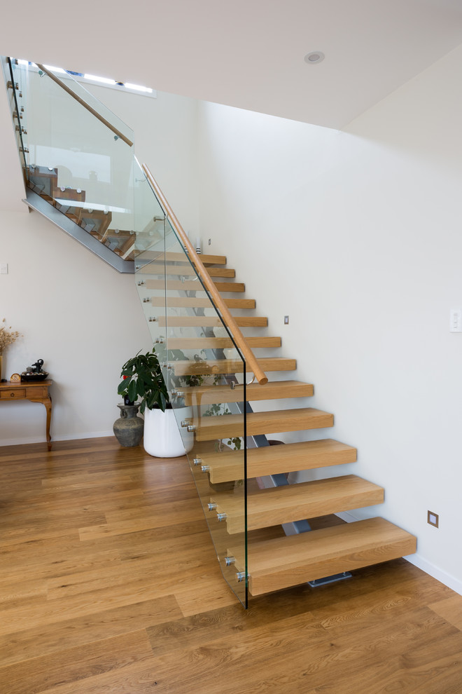 Ejemplo de escalera suspendida minimalista de tamaño medio sin contrahuella con escalones de madera