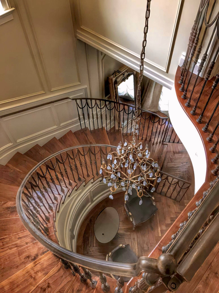 Inspiration for a large timeless wooden curved metal railing and wall paneling staircase remodel in Los Angeles with painted risers