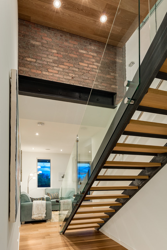 На фото: огромная прямая лестница в стиле неоклассика (современная классика) с деревянными ступенями без подступенок с