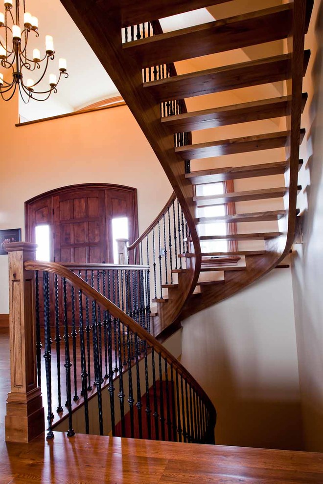 Стильный дизайн: изогнутая лестница среднего размера в стиле кантри с деревянными ступенями без подступенок - последний тренд