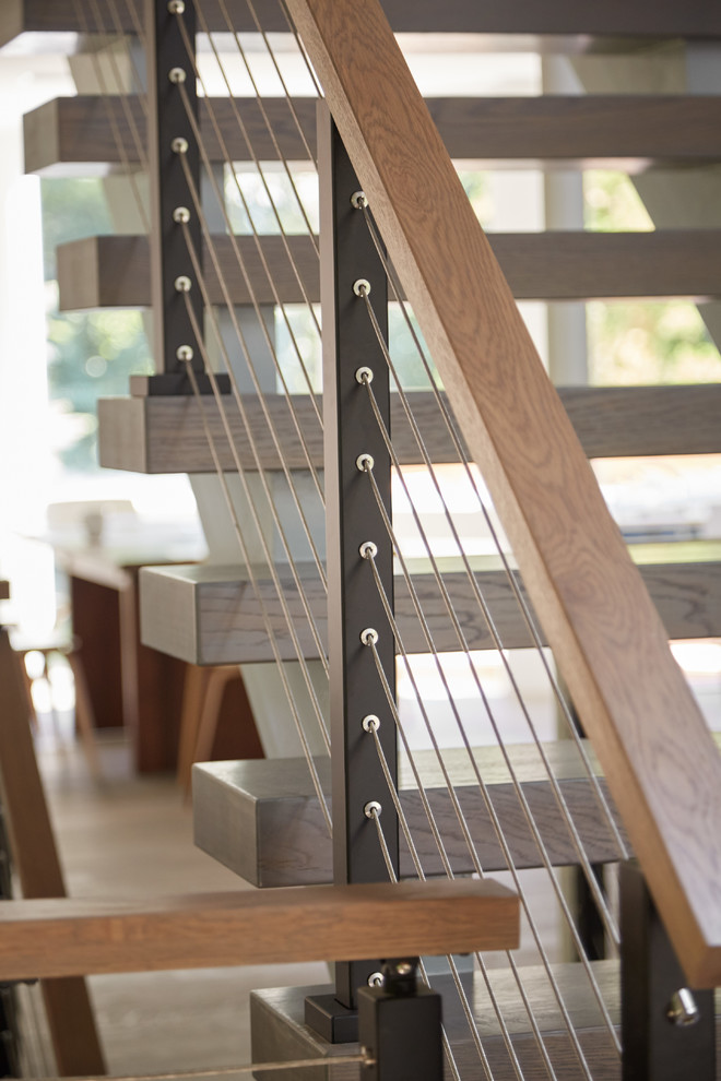 Свежая идея для дизайна: большая лестница на больцах в стиле модернизм с деревянными ступенями и деревянными перилами - отличное фото интерьера