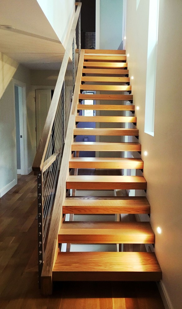 Imagen de escalera recta actual de tamaño medio sin contrahuella con escalones de madera y barandilla de cable