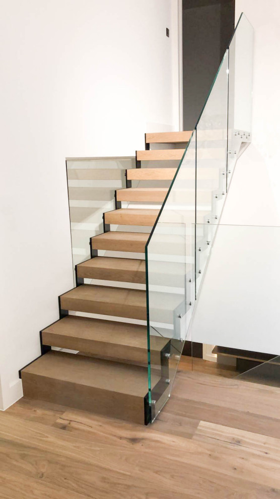 Cette photo montre un escalier sans contremarche droit tendance de taille moyenne avec des marches en bois et un garde-corps en verre.