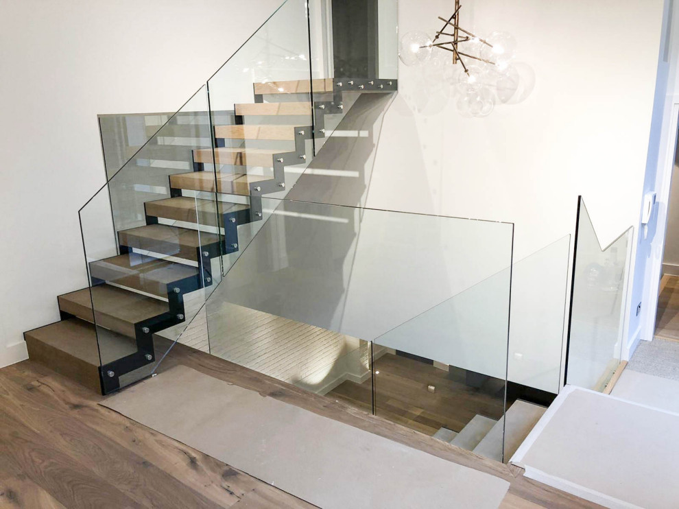 Aménagement d'un escalier sans contremarche droit contemporain de taille moyenne avec des marches en bois et un garde-corps en verre.