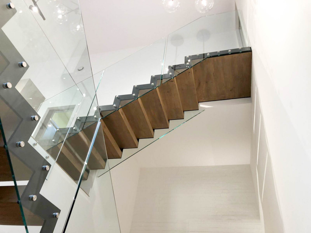 ロンドンにあるお手頃価格の中くらいなコンテンポラリースタイルのおしゃれな階段 (ガラスフェンス) の写真
