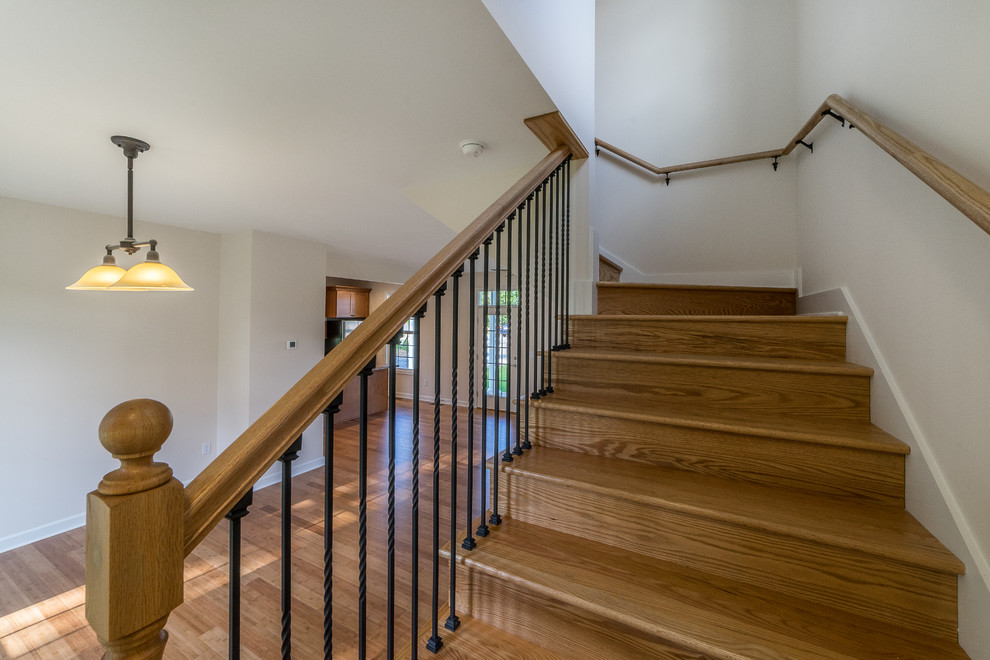 Diseño de escalera en L clásica pequeña con escalones de madera, contrahuellas de madera y barandilla de metal
