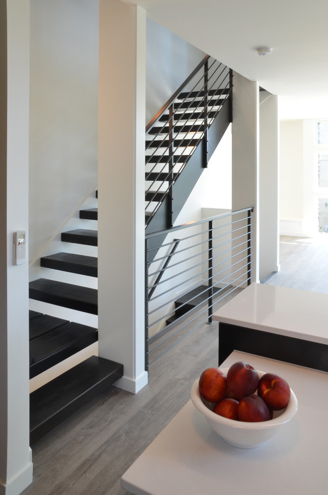 Photo of a medium sized contemporary wood u-shaped metal railing staircase with open risers.