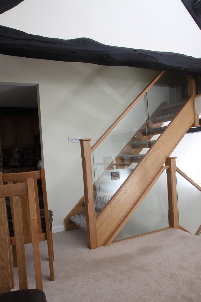 Источник вдохновения для домашнего уюта: прямая лестница в современном стиле с ступенями с ковровым покрытием, ковровыми подступенками и стеклянными перилами