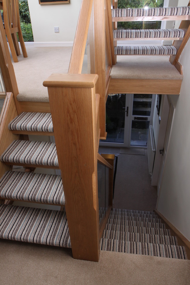 Foto de escalera recta contemporánea con escalones enmoquetados, contrahuellas enmoquetadas y barandilla de vidrio