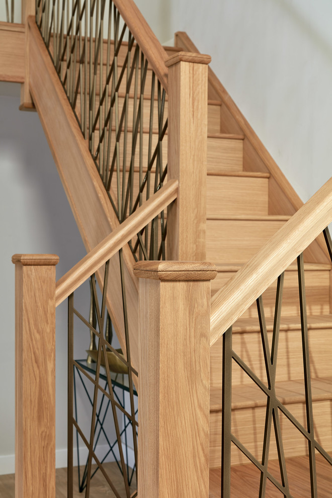 Ejemplo de escalera en U urbana grande con escalones de madera, contrahuellas de madera y barandilla de metal