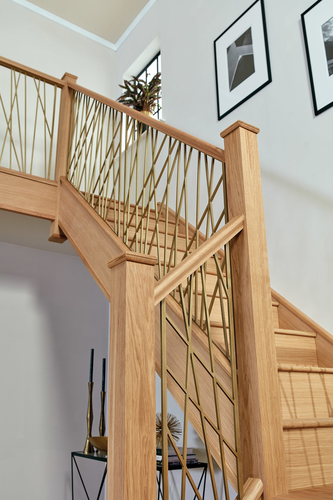 Inspiration for a large contemporary wood u-shaped metal railing staircase in Manchester with wood risers.