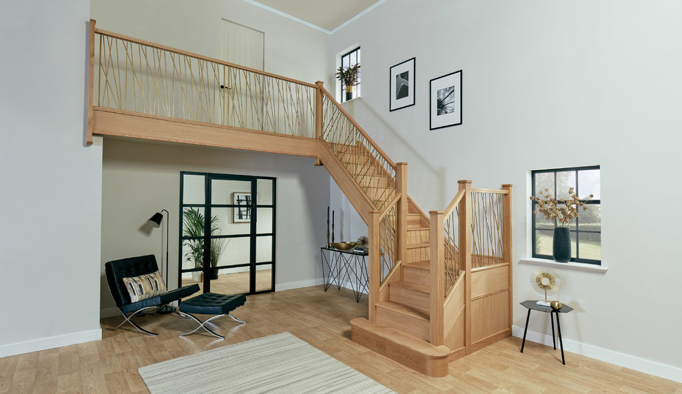 Aménagement d'un grand escalier contemporain en U avec des marches en bois, des contremarches en bois et un garde-corps en métal.