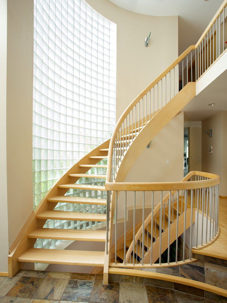Imagen de escalera curva contemporánea sin contrahuella con escalones de madera y barandilla de madera