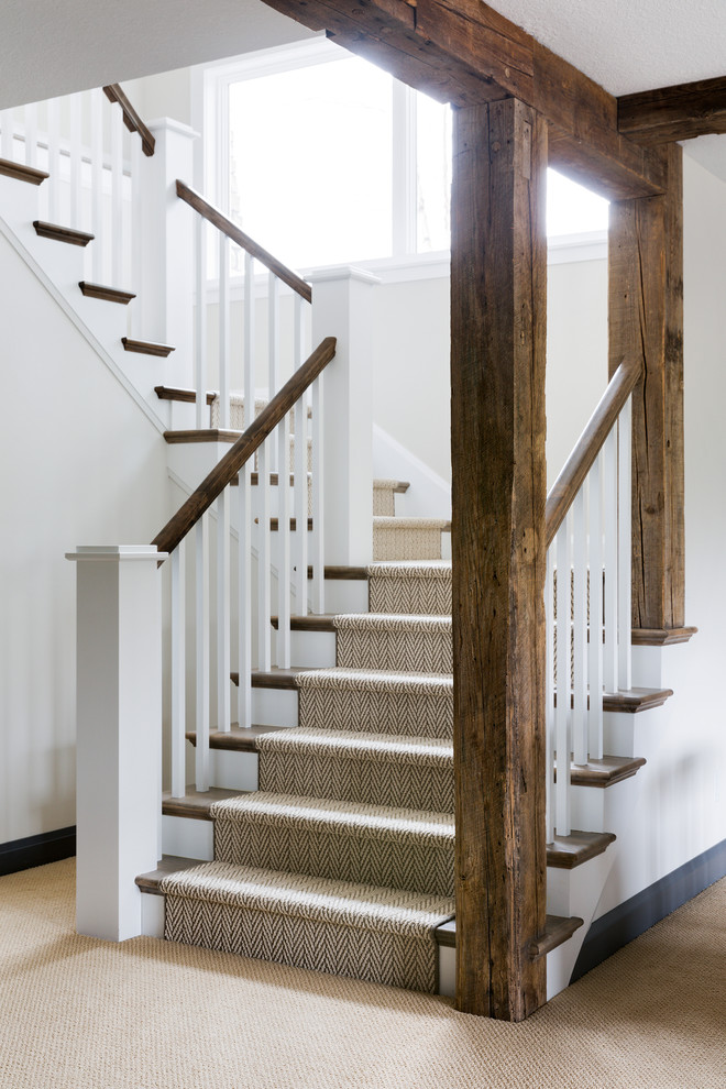 На фото: большая п-образная лестница в морском стиле с деревянными ступенями, крашенными деревянными подступенками и деревянными перилами с