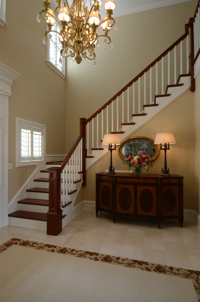 Пример оригинального дизайна: большая угловая лестница в классическом стиле с деревянными ступенями
