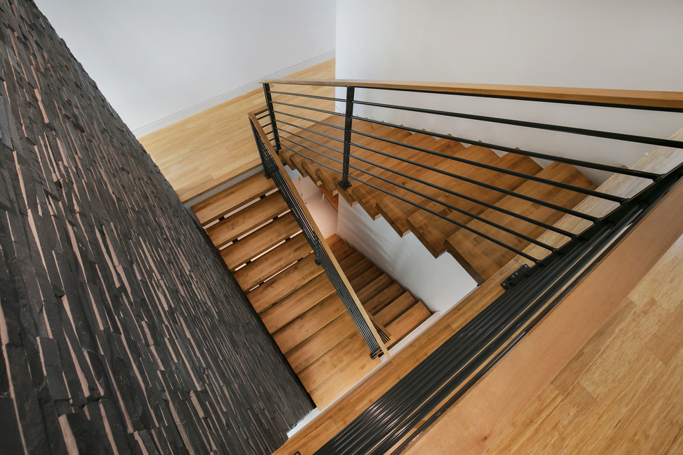 Идея дизайна: большая п-образная лестница в стиле модернизм с деревянными ступенями и перилами из смешанных материалов без подступенок