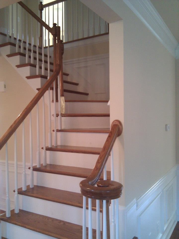 На фото: угловая бетонная лестница в классическом стиле с крашенными деревянными ступенями