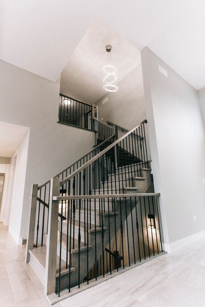 Imagen de escalera en L minimalista grande con escalones de madera pintada, contrahuellas de madera pintada y barandilla de varios materiales