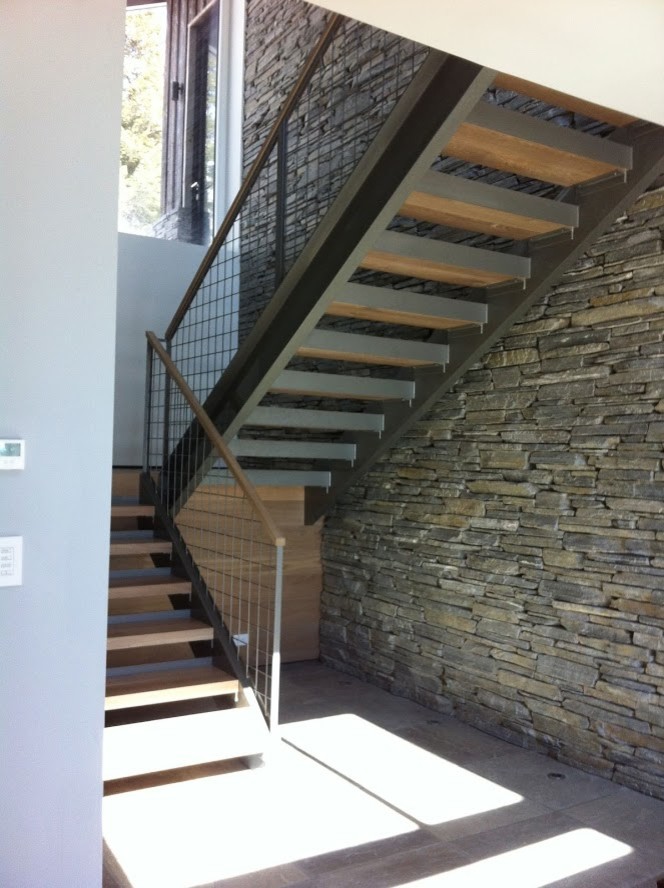 Design ideas for a large modern wood u-shaped metal railing staircase in Other with open risers.