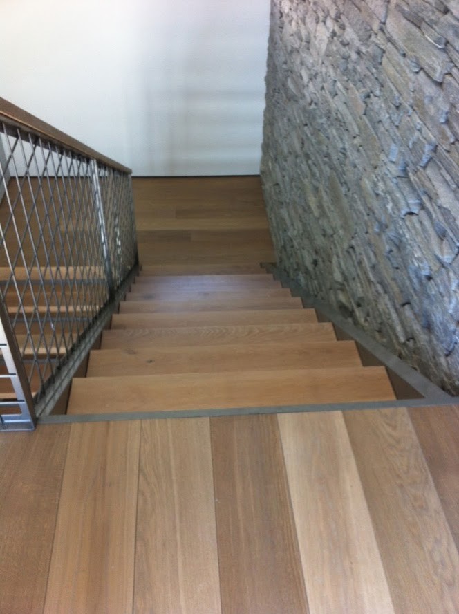 На фото: большая п-образная лестница в стиле модернизм с деревянными ступенями и металлическими перилами без подступенок с
