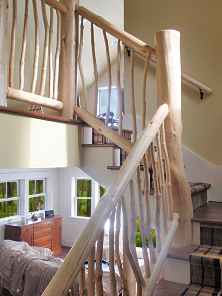 Ejemplo de escalera en L rústica de tamaño medio con escalones enmoquetados, contrahuellas enmoquetadas y barandilla de madera