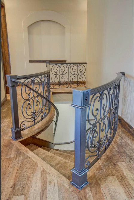 This is an example of a medium sized classic wood curved staircase in Wichita with wood risers.