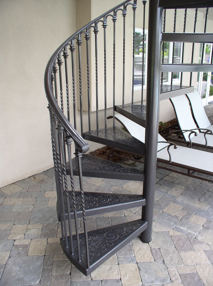 Inspiration för mellanstora klassiska svängda trappor i metall, med öppna sättsteg och räcke i metall
