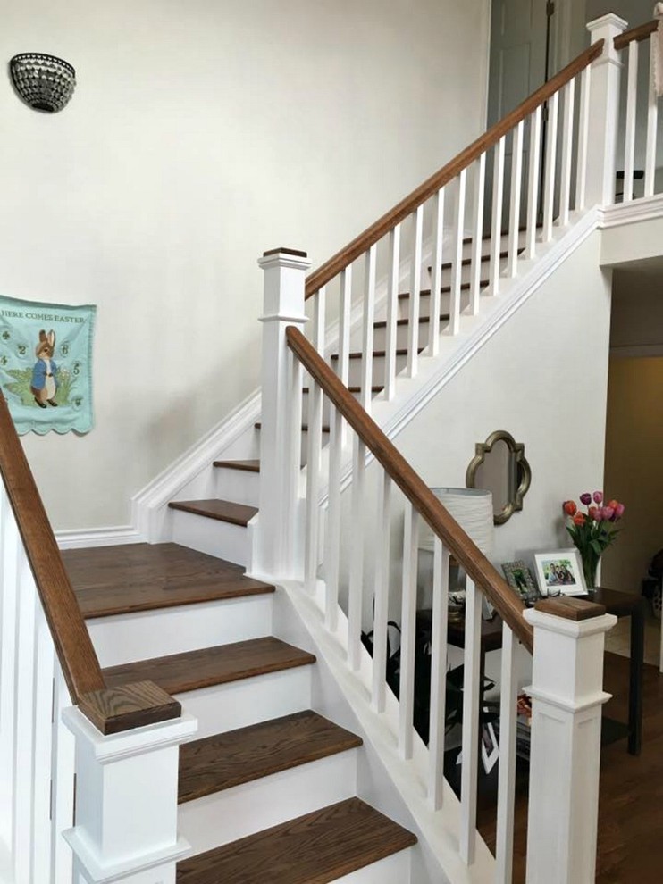 Imagen de escalera en L tradicional de tamaño medio con escalones de madera, contrahuellas de madera pintada y barandilla de madera