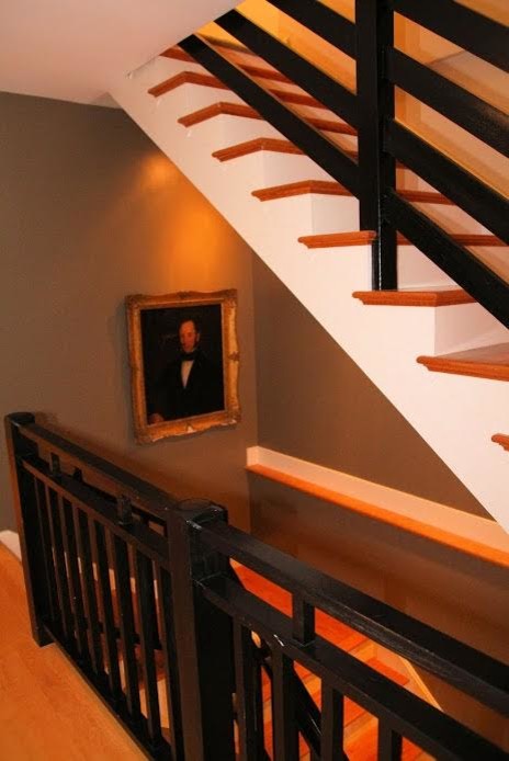 Réalisation d'un escalier peint courbe tradition de taille moyenne avec des marches en bois et un garde-corps en métal.