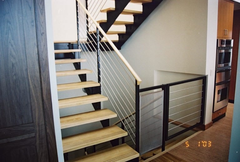 Foto di una scala a "U" design di medie dimensioni con pedata in legno, nessuna alzata e parapetto in legno