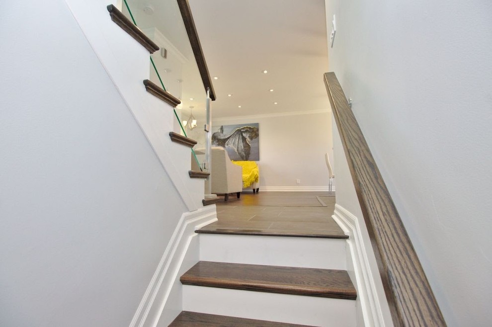 Mid-sized transitional wooden u-shaped glass railing staircase photo in Toronto with painted risers