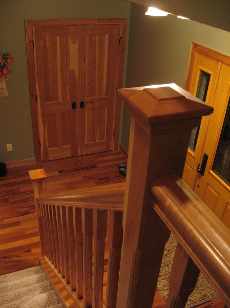 Пример оригинального дизайна: прямая лестница среднего размера в стиле кантри с деревянными ступенями, ковровыми подступенками и деревянными перилами