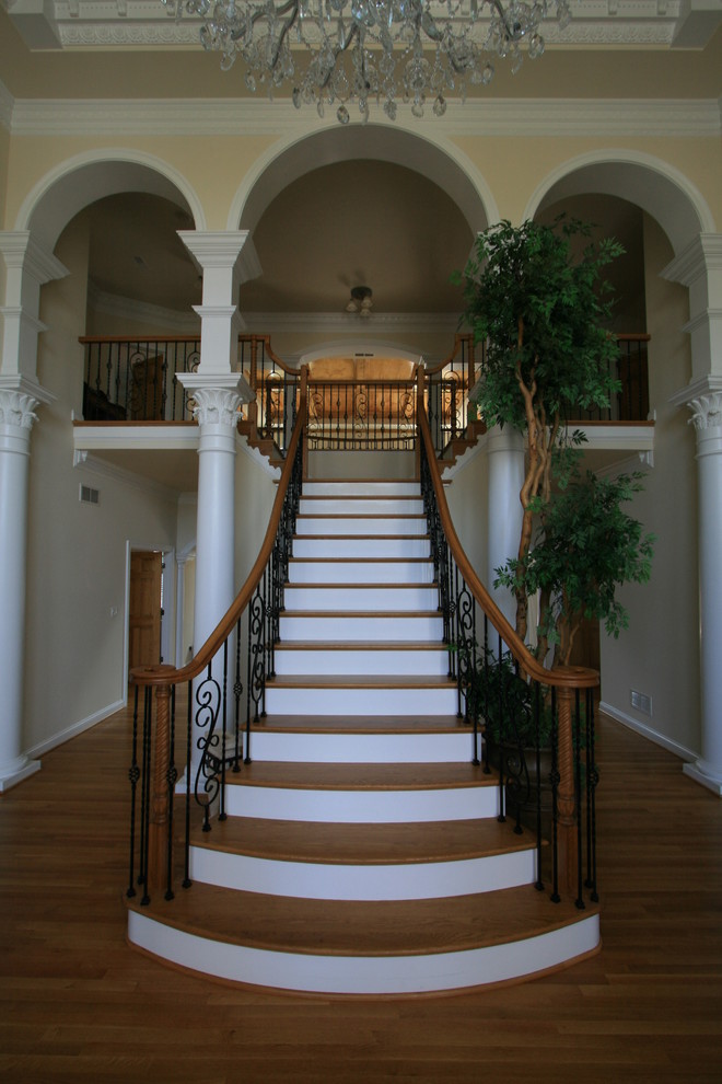 Ejemplo de escalera recta clásica de tamaño medio con escalones de madera, contrahuellas de madera pintada y barandilla de metal