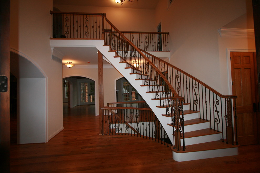 Ejemplo de escalera curva tradicional grande con escalones de madera, contrahuellas de madera pintada y barandilla de varios materiales
