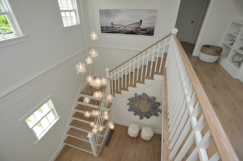 Diseño de escalera en U costera de tamaño medio con escalones de madera, contrahuellas de madera pintada y barandilla de madera