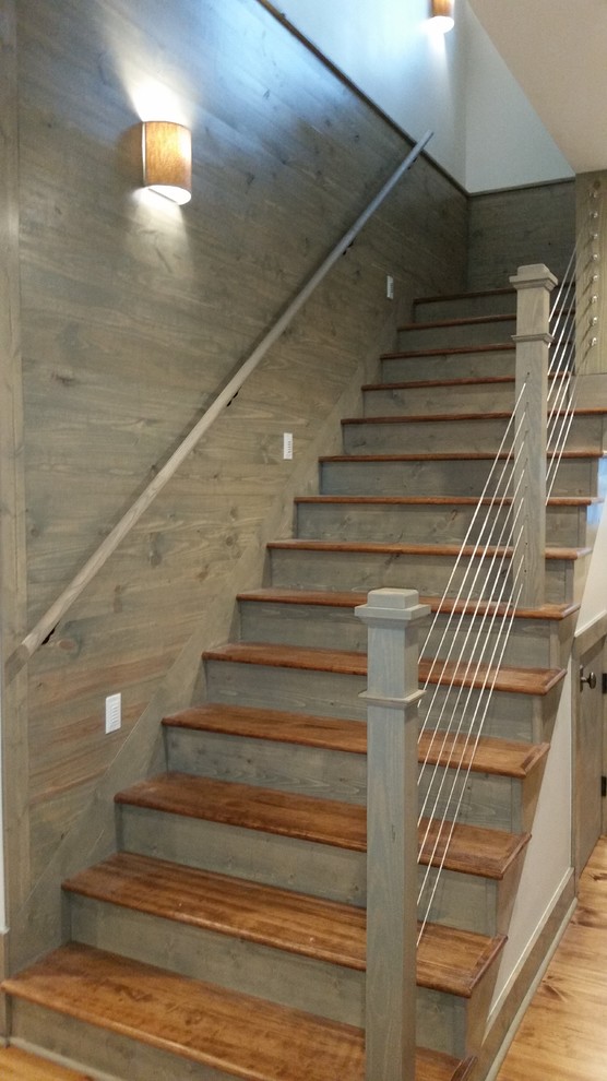 Photo of a small traditional wood l-shaped wire cable railing staircase in Other with wood risers.