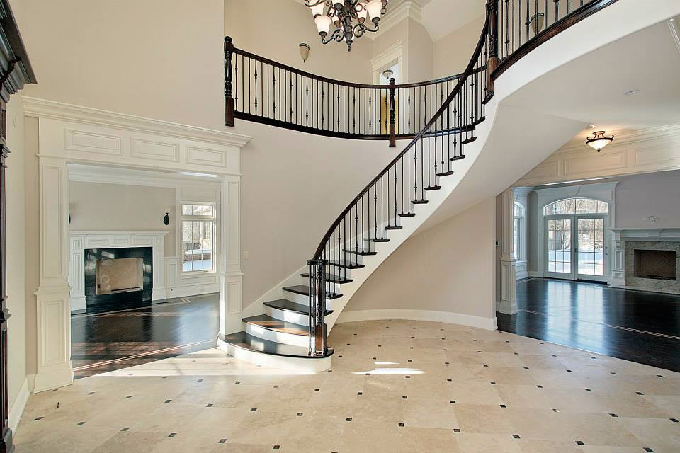 Example of a large classic wooden curved mixed material railing staircase design in Los Angeles with painted risers