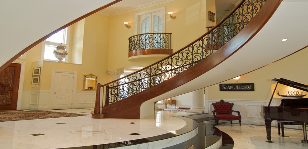 Источник вдохновения для домашнего уюта: огромная изогнутая лестница в классическом стиле с деревянными ступенями